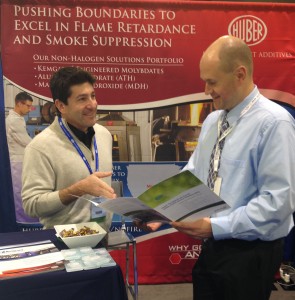 Huber's Omar Mureebe (left) discusses with an IWCS attendee the benefits of Huber's Fire Retardant Additives in Wire & Cable applications.