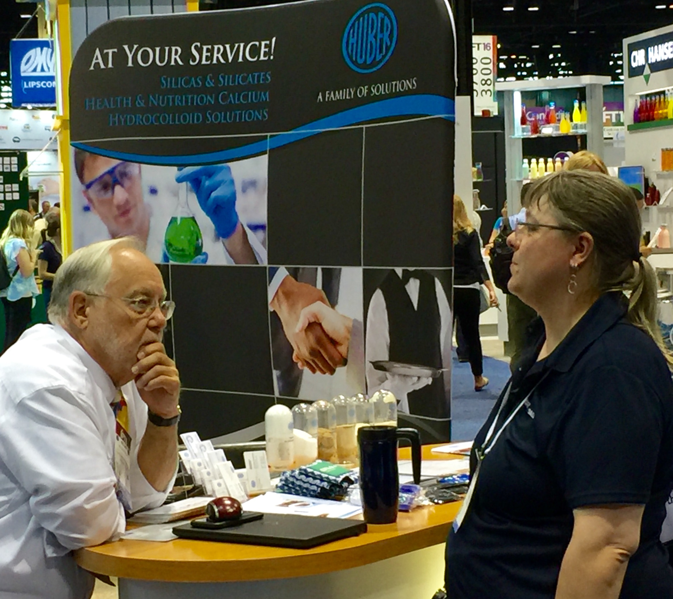 Huber's Sr. Technical Service Representative Nolan Phillps (left) fields questions about Huber's Silicas and Silicates at IFT2016.